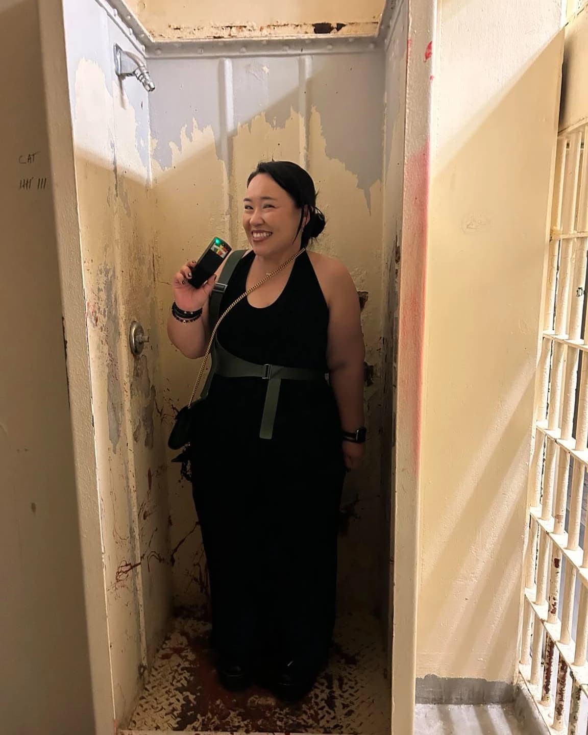 A guest using a spirit box inside a former cell during the investigation