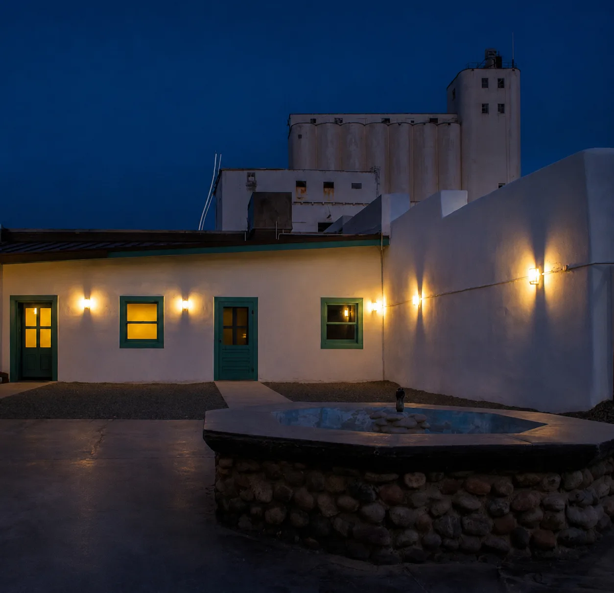El patio de la Hayden House en Tempe de noche, con los silos del Molino Hayden detrás