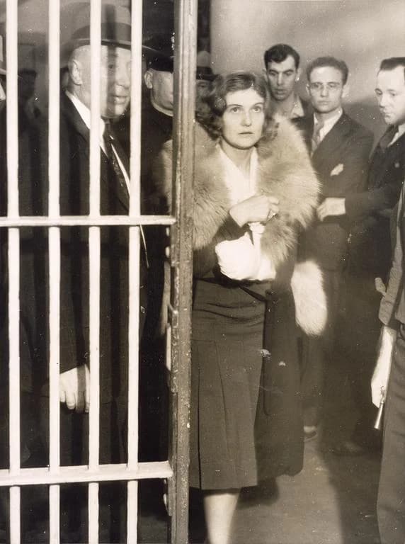 Winnie Ruth Judd bajo custodia, fotografiada en la reja de la cárcel rodeada de agentes y reporteros